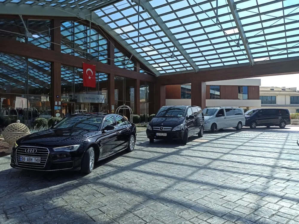  Luxury transfer vehicles and Audi A6 parked in front of Hilton Dalaman Resort entrance - VIP transportation between air